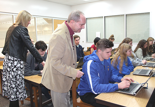 Mathews County Electoral Board Secretary Jeff Bohn, center, assists Mathews High School senior Josh Monastyrly as he registers to vote. Bohn, Electoral Board President Josie Thorpe (not pictured), and Mathews Voter Registrar Carla Faulkner, at left, worked with seniors over a two-day period to encourage them to participate in elections. The students shown here are in teacher Al Thomas’s Honors U.S. Government class. Photo by Sherry Hamilton