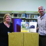 RUBY WILLIAMS / GAZETTE-JOURNAL Diane Rebertus, director of the Gloucester Library, accepts a donation of three books of Gloucester history from Gloucester Museum of History director Robert Kelly. The books are available in The Virginia Room of the library, Main Street Center.