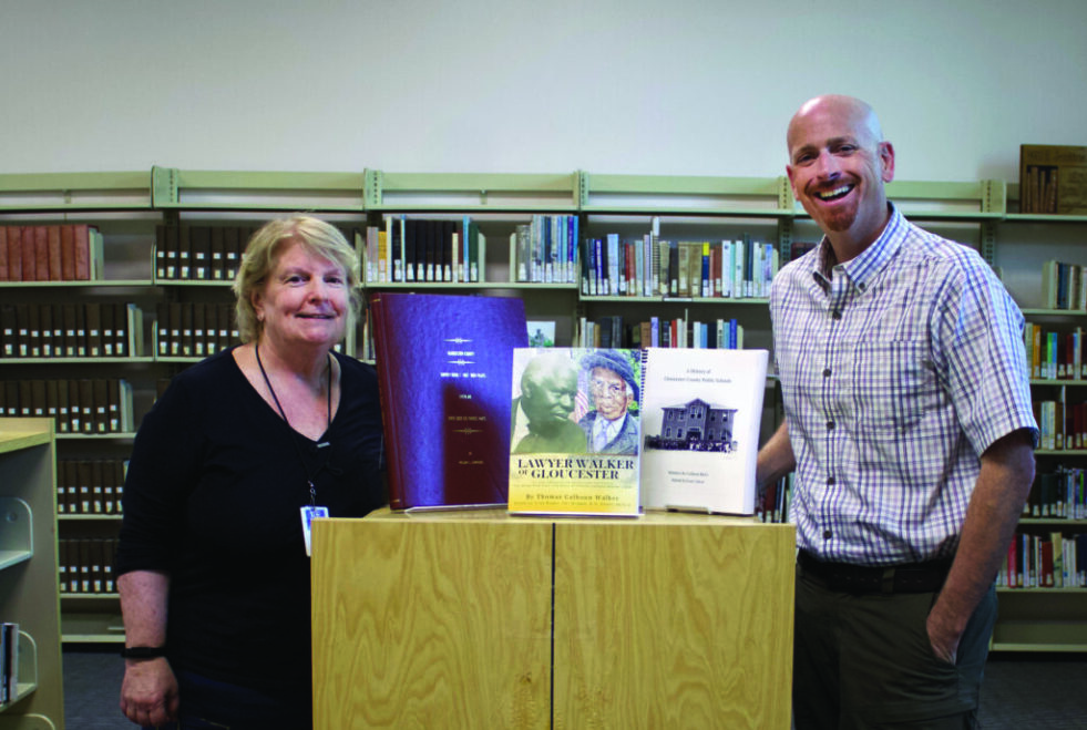 RUBY WILLIAMS / GAZETTE-JOURNAL Diane Rebertus, director of the Gloucester Library, accepts a donation of three books of Gloucester history from Gloucester Museum of History director Robert Kelly. The books are available in The Virginia Room of the library, Main Street Center.